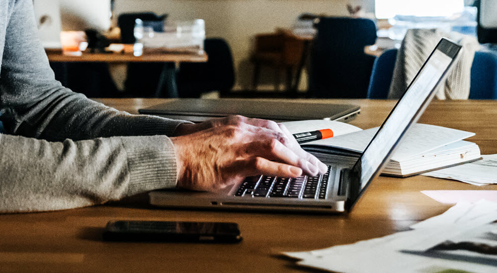 Male hands typing on laptop